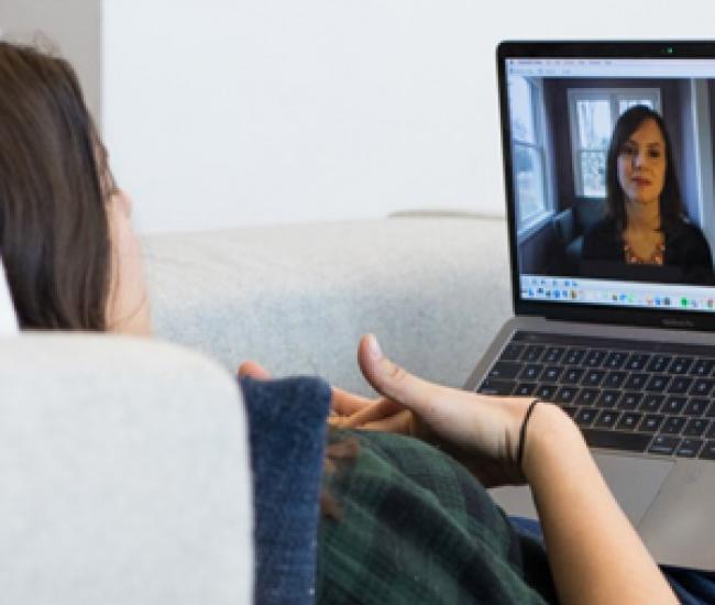Woman speaking with her therapist via through her laptop