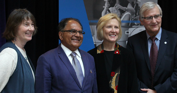 four people standing and smiling