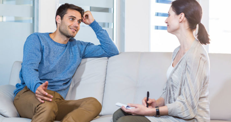 man and woman sitting on a couch and talking