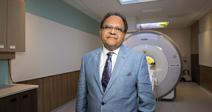 Zul Merali standing in front of MRI machine