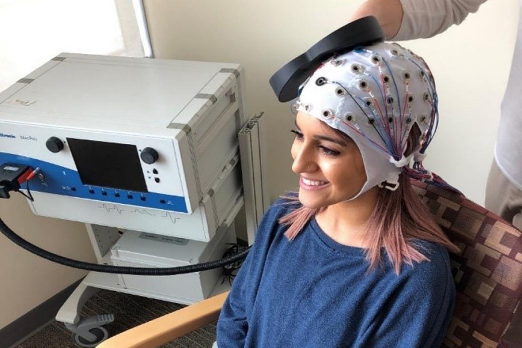 A woman wearing a Repetitive transcranial magnetic stimulation (rTMS).