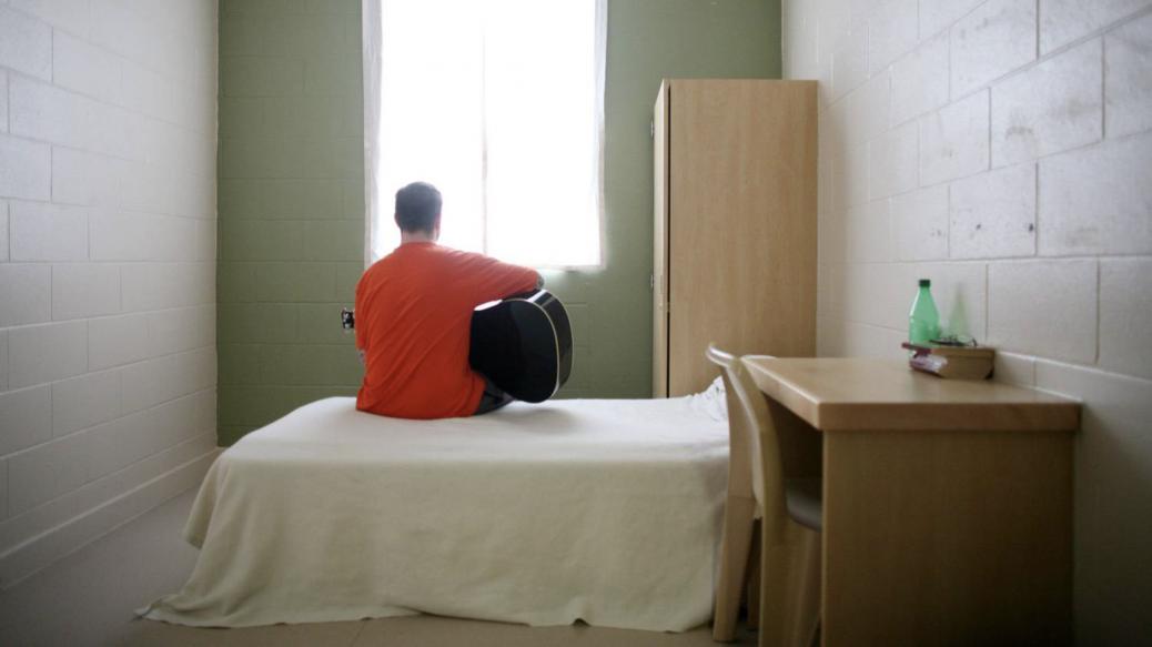 Patient playing guitar while sitting on bed in bedroom