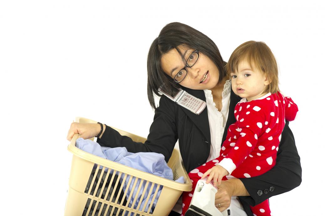 Mother holding baby in one arm and laundry basket in the other