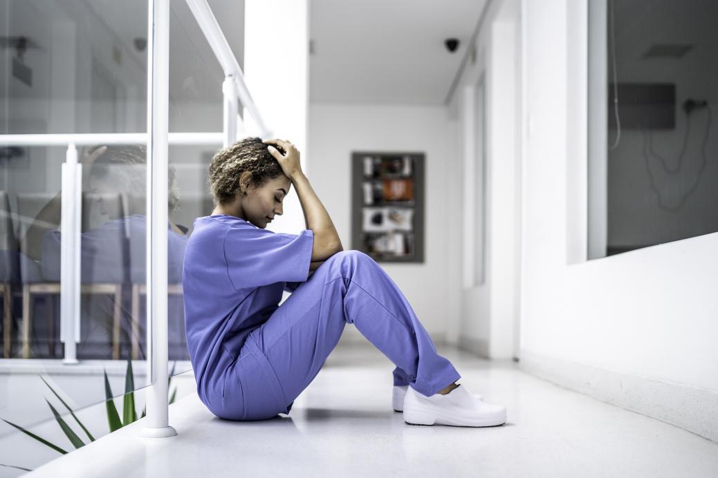Exhausted health care worker sitting on floor