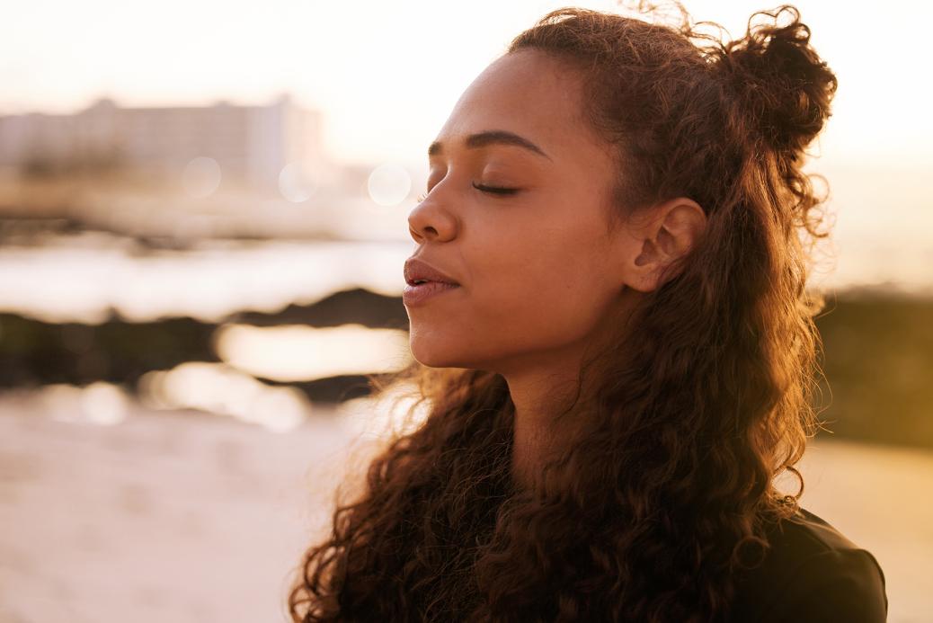 Woman with closed eyes taking in a deep breath