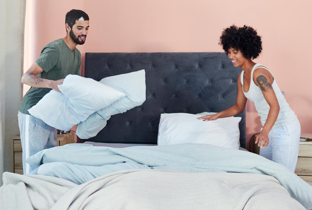 Two people making a bed