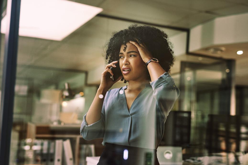 Woman on a phone with an expression of shock