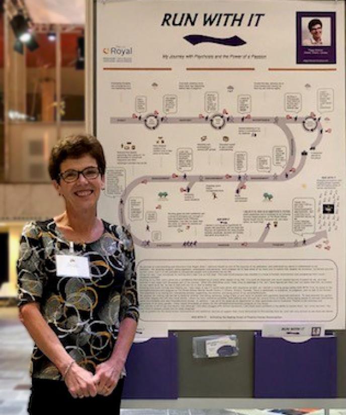 Peggy Hickman standing beside the poster she created