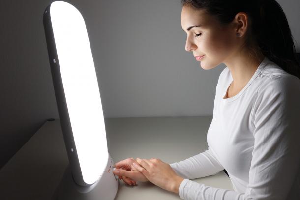 Woman using a light therapy lamp