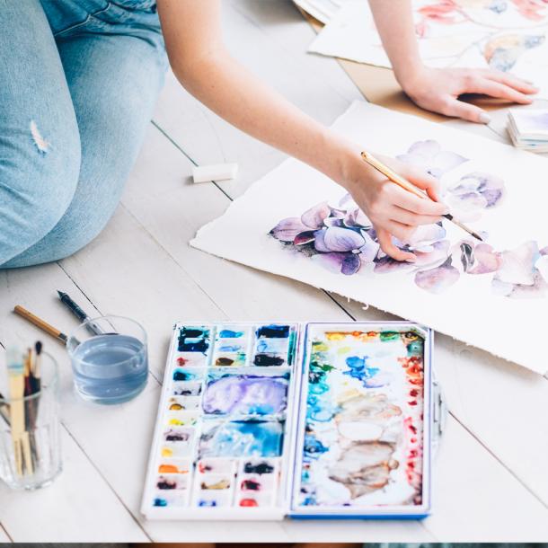 Person sitting on floor painting with watercolours