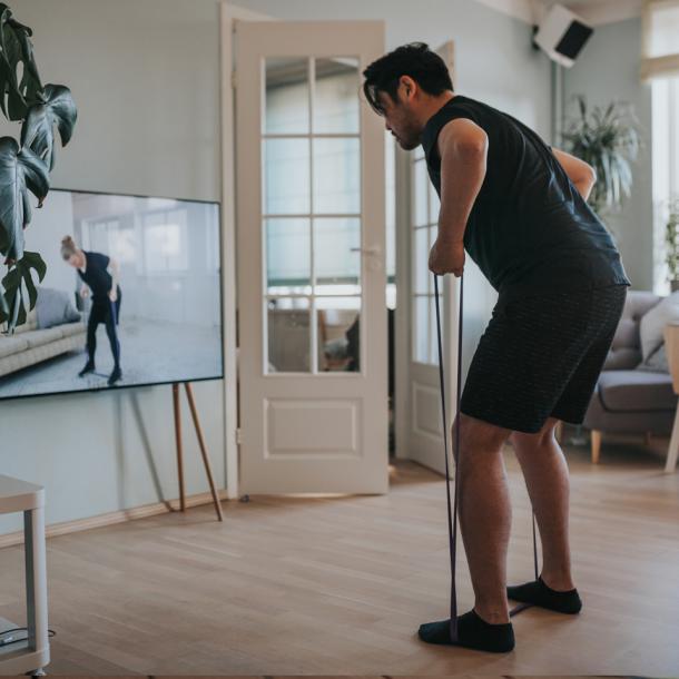 Man exercising with a program on TV