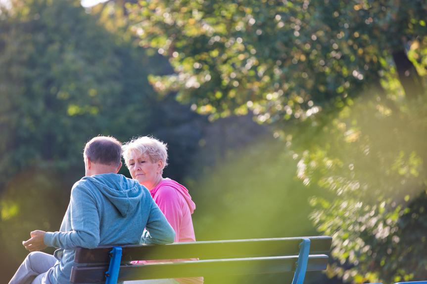 Man and woman sitting on a bench outside