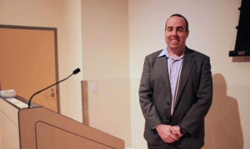 Dr. Tyler Black standing behind podium giving his presentation