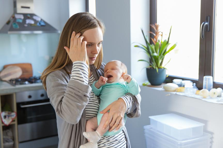 Exhausted mom holding her infant