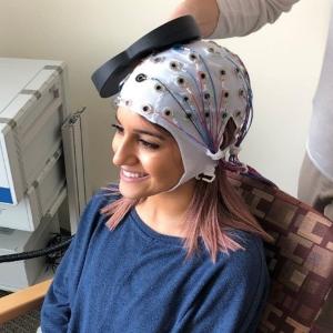 Une femme portant une casquette pour la stimulation magnétique transcrânienne répétitive (rTMS)