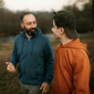 A man speaking with a teenager