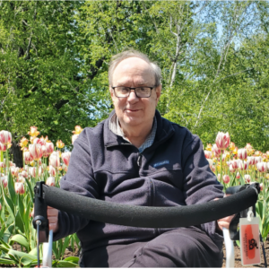 Richard sitting in front of a tulip garden