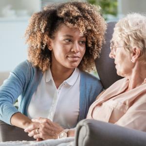 A mental health worker with a senior client in her home.