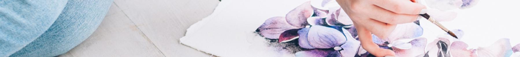 Person sitting on floor painting with watercolours