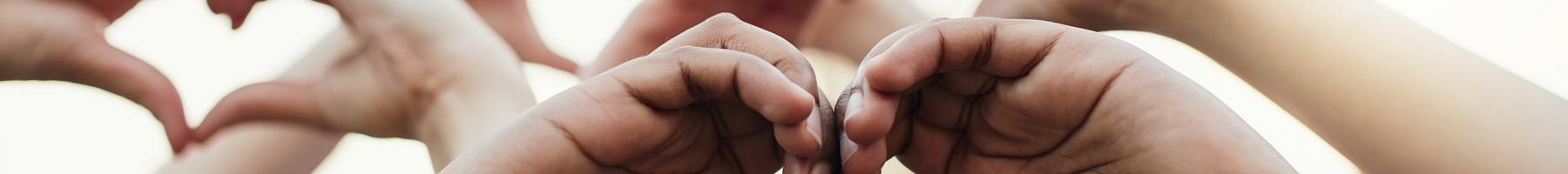 Several hands making a the heart symbol