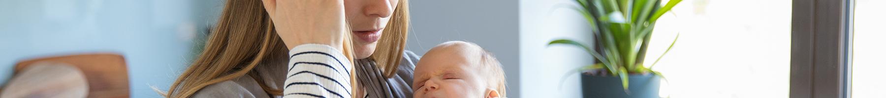 An exhausted mother holding her infant