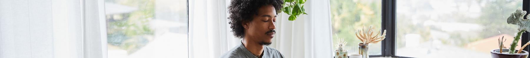 Man sitting on bed meditating 