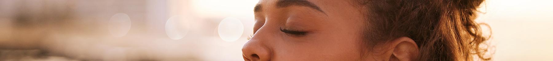 Looking after your own wellness Woman with closed eyes taking in a deep breath