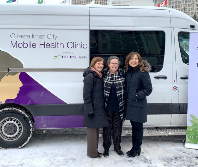 Dr. Susan Farrell, vice president of patient care services and community mental health at The Royal; Wendy Muckle, CEO of Ottawa Inner City Health; and Jill Schnarr, vice president of corporate citizenship and communications at Telus in front of van.