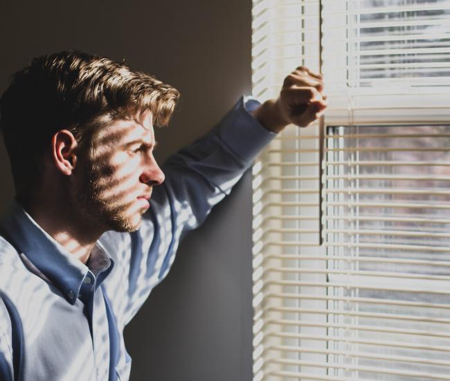 Man looking out window