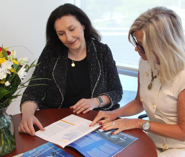 Dr. Florence Dzierszinski and Cara Vaccarino reading the Research Strategic Plan