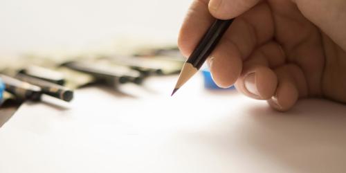A Hand holding a pencil while sketching group designed to create and heal