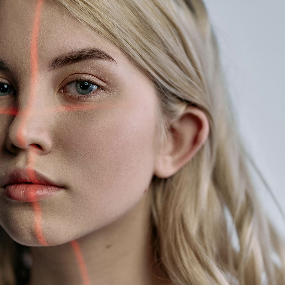 A young woman looks into the camera, with laser lines mapping out her face