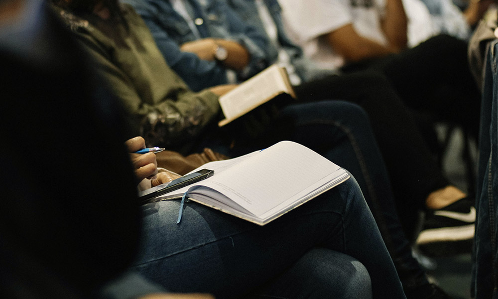 A group of people writing in notebooks