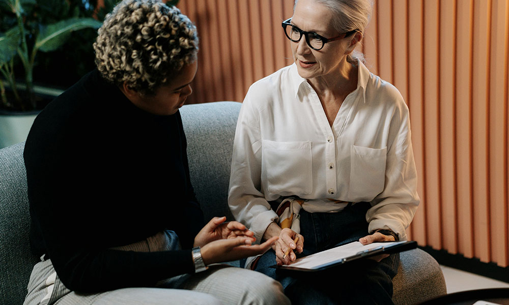 Two people consult information on a clipboard
