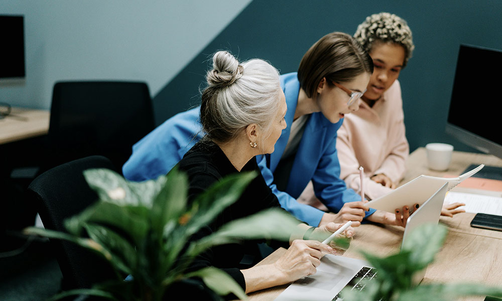 Three women discuss work together